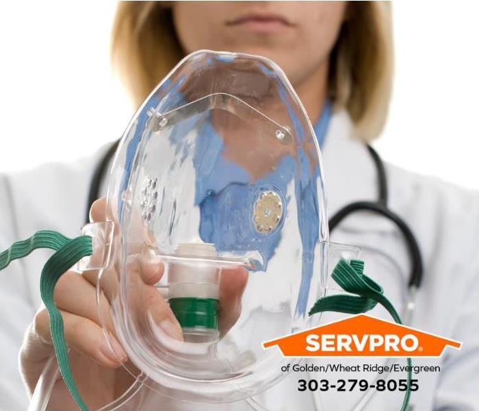 A medical professional is holding a medical oxygen mask. 